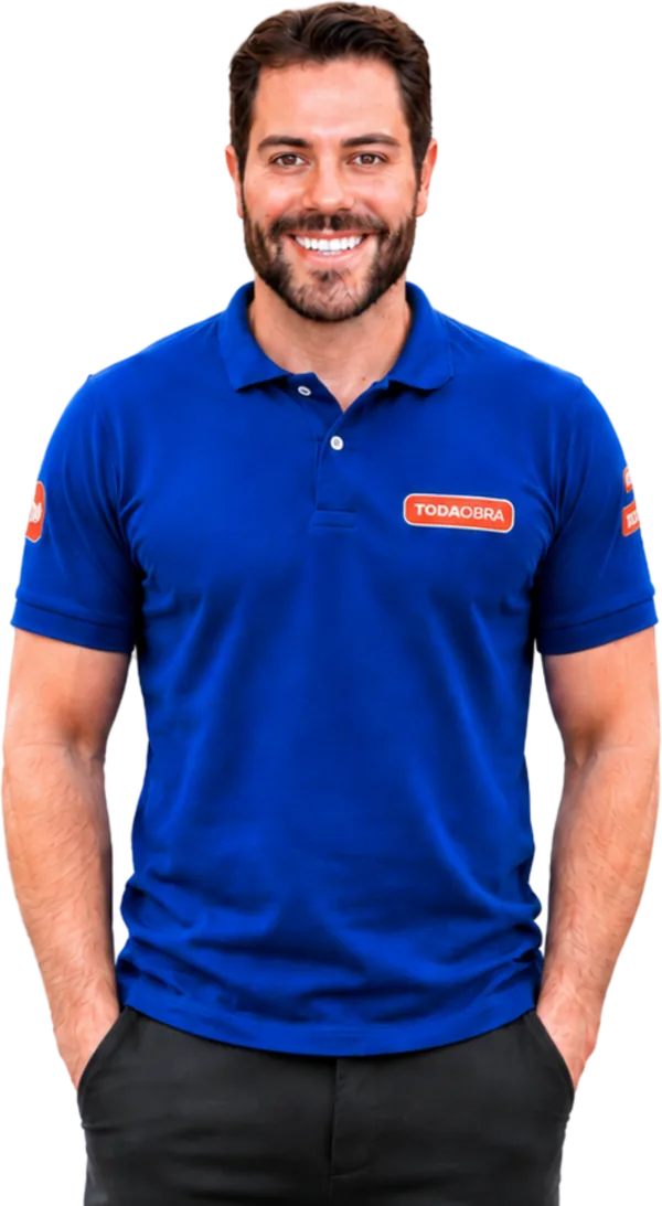 Pedro Junior, fundador da Toda Obra Home Center, ao lado de uma placa com a marca da loja